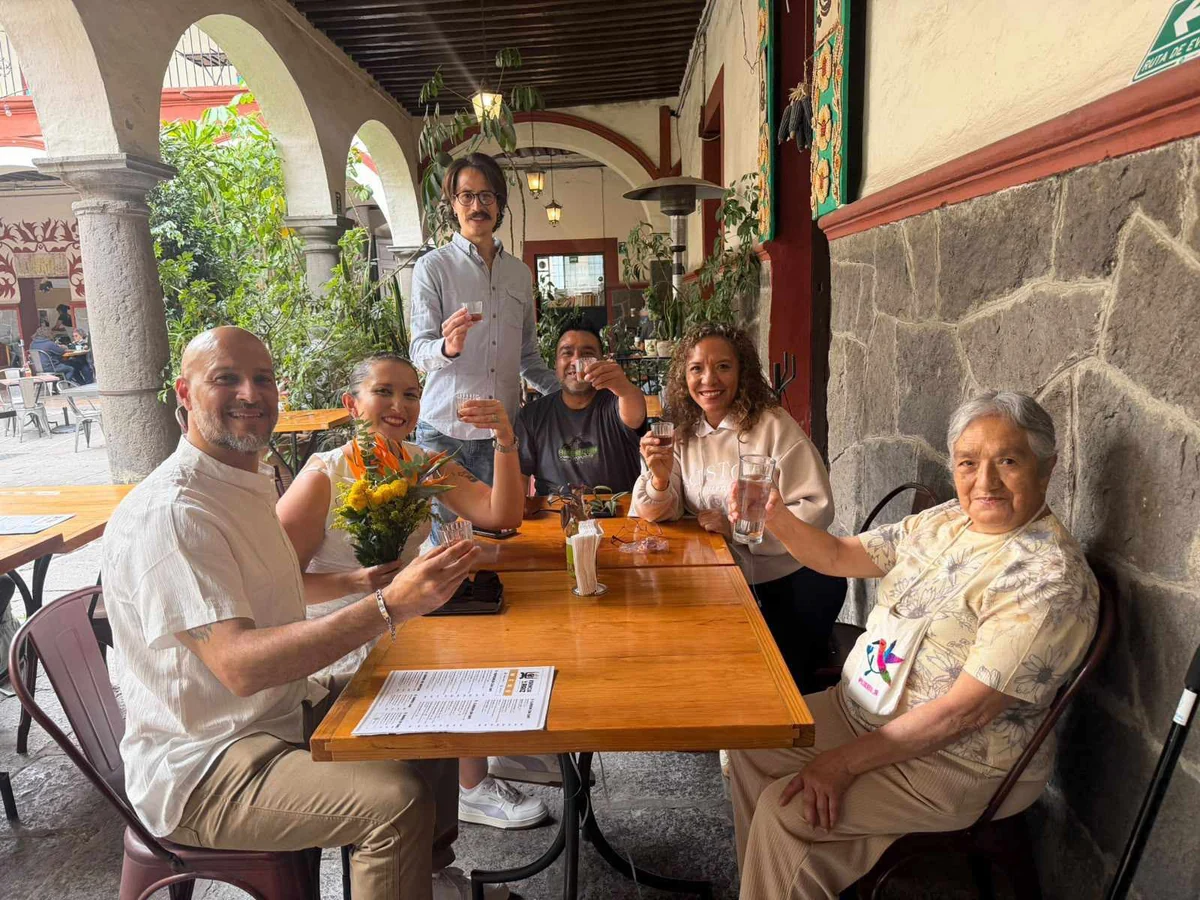 Grupo de clientes brindando en una mesa del portal de la casona de Esencia y Raíz